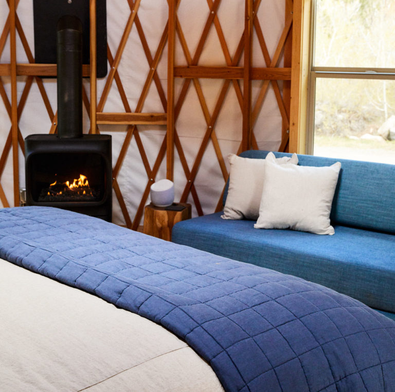 Bed, fire place, and couch in yurt