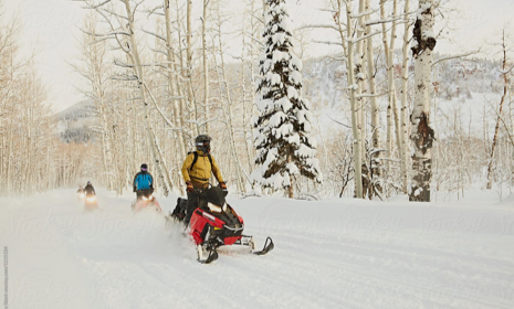 Snowmobilers riding in the mountains
