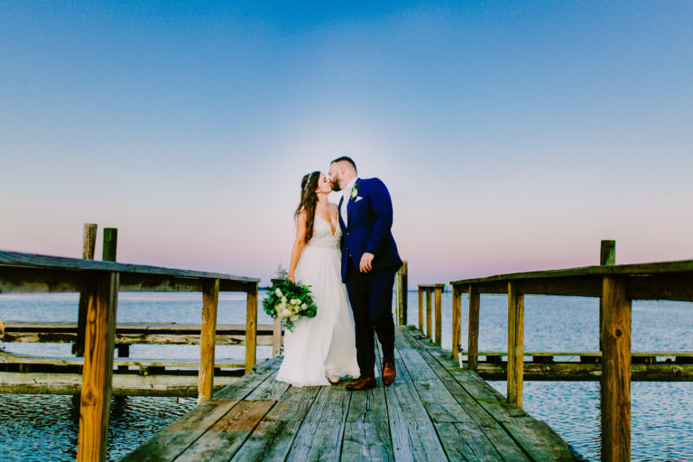 Bride and groom kissing on the dock