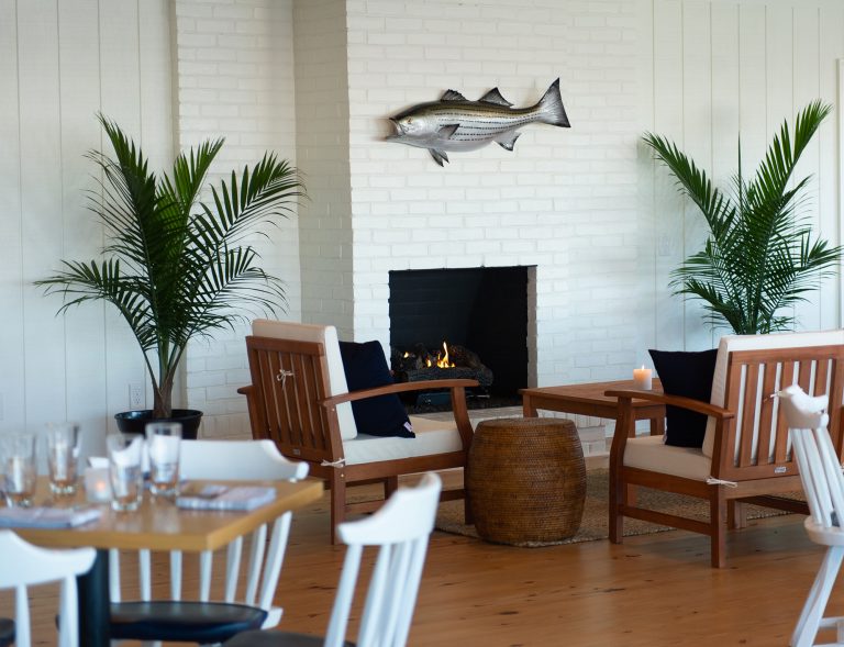 seating area next to fire place with art piece of a fish hanging