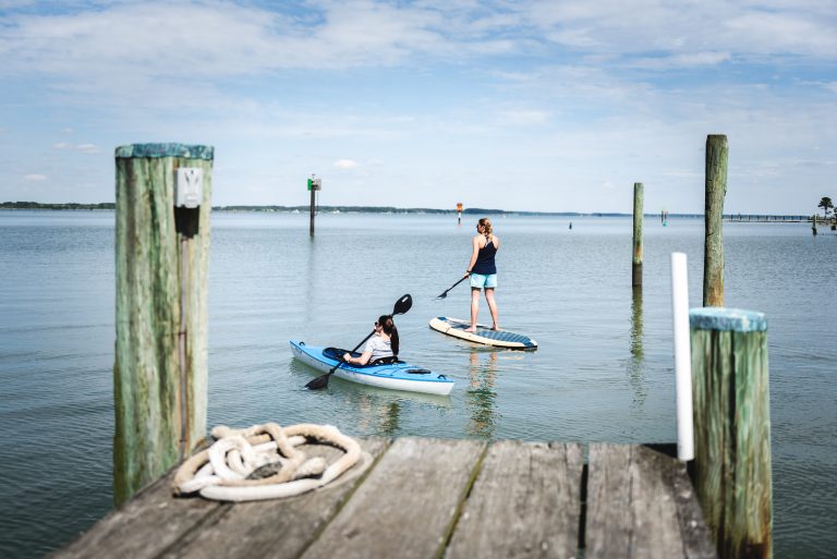 Two woman on a canoe and stand up paddle board